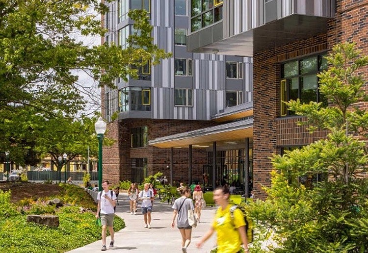 people walking on a sidewalk in front of Unthank Hall