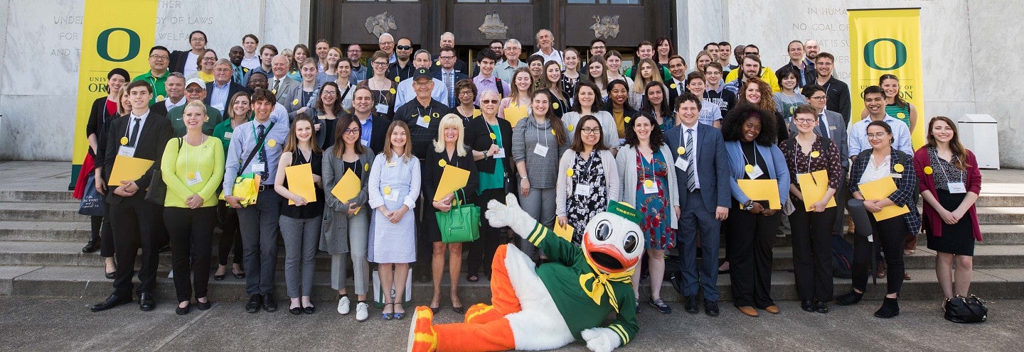 A large group of UO Advocates with The Duck on the steps of the Oregon State Capitol building.