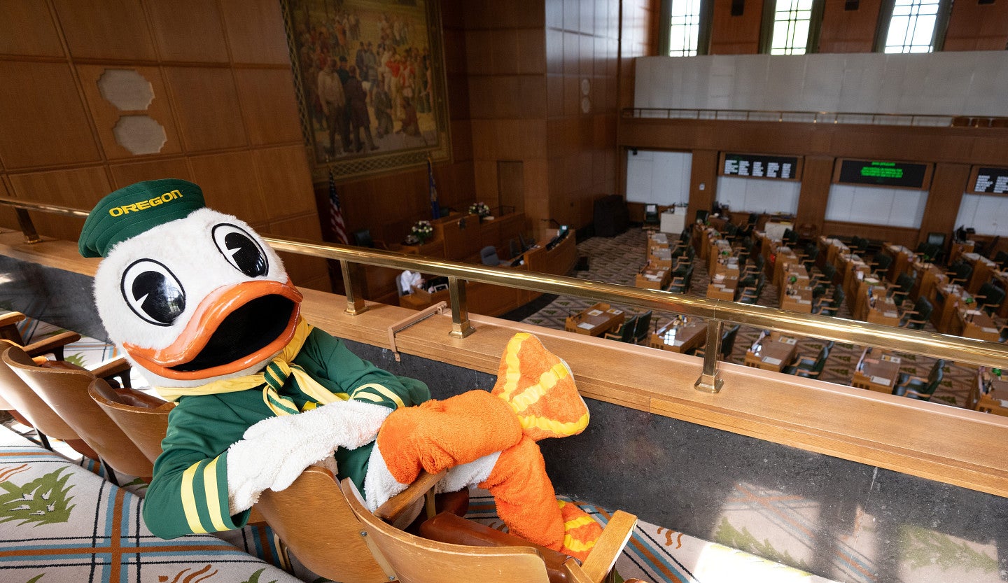 The Duck reclines across two seats in the Oregon State Senate gallery.