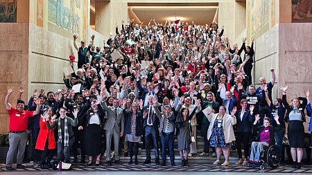 More than 200 advocates gather for a group photo on the steps of the Oregon State Capitol rotunda