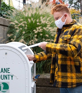 Student turning in ballot on campus