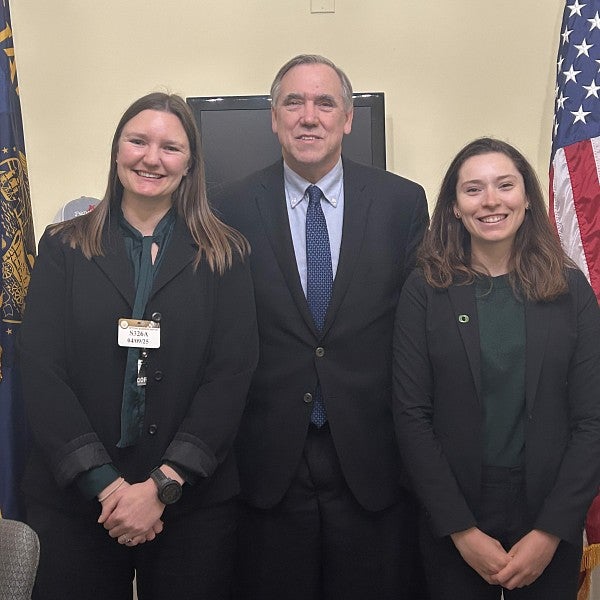 UO doctoral candidates Ann-Marie Barrett and Lia Strait posing for a picture with US Senator Jeff Merkley